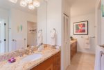 The spacious bathroom has twin vanities with sinks and granite counter tops